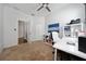 Bright office space with neutral carpet, white desk, shelving, and modern ceiling fan at 205 Lakeshore Dr, Davenport, FL 33837