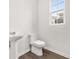 Powder room featuring a sleek pedestal sink and toilet at 2108 Celebration Blvd, Celebration, FL 34747