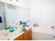 Bathroom featuring double sinks, a large mirror, and a separate tub, with natural light from the window at 2268 Victoria Falls Dr, Orlando, FL 32824