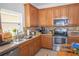 Kitchen with stainless steel appliances, wood cabinets, tile countertops, and a kitchen sink at 2268 Victoria Falls Dr, Orlando, FL 32824