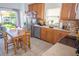 Eat-in kitchen with stainless steel appliances, wood cabinets, tile countertops, and a dining table at 2268 Victoria Falls Dr, Orlando, FL 32824