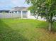 Expansive backyard with lush grass, white fence, and large tree at 2479 White Lilly Dr, Kissimmee, FL 34747