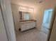 A spacious bathroom boasts a double sink vanity with granite countertop and tiled floors at 2479 White Lilly Dr, Kissimmee, FL 34747