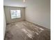 Spacious bedroom with a window bringing in natural light and plush carpeting at 2479 White Lilly Dr, Kissimmee, FL 34747