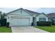 Charming single-story home with a two-car garage, manicured lawn, and neutral color palette at 2479 White Lilly Dr, Kissimmee, FL 34747