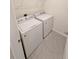 Laundry room featuring modern, white, front-load washer and dryer on tiled floor at 2479 White Lilly Dr, Kissimmee, FL 34747