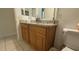 Bathroom features a double sink vanity with granite countertop and framed mirror at 2646 Quarterdeck Ct, Kissimmee, FL 34743