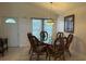 Dining room showcases a glass-topped table, wicker chairs, hanging light, and large window at 2646 Quarterdeck Ct, Kissimmee, FL 34743