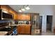 Well-lit kitchen featuring stainless steel appliances, tile backsplash, and wood cabinets at 2646 Quarterdeck Ct, Kissimmee, FL 34743