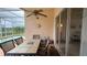 Covered patio with a table and chairs overlooking the pool and lake at 2646 Quarterdeck Ct, Kissimmee, FL 34743