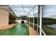 A screened-in pool with adjacent patio, dining table and barbeque and scenic lake views at 2646 Quarterdeck Ct, Kissimmee, FL 34743