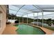 Screened-in pool and scenic lake views and adjacent patio with barbeque at 2646 Quarterdeck Ct, Kissimmee, FL 34743