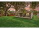 View of a home's green backyard, brick fence and enclosed patio with decorative lighting at 2700 Palm Isle Way, Orlando, FL 32829