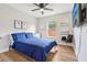 Bright bedroom with a queen-sized bed, wood floors, ceiling fan, and a large window allowing ample natural light at 2700 Palm Isle Way, Orlando, FL 32829