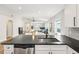 Open concept kitchen and living area with black countertops, stainless steel appliances, and ample natural light at 2700 Palm Isle Way, Orlando, FL 32829