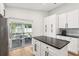 Bright kitchen island with black countertops with access to a screened patio featuring outdoor dining at 2700 Palm Isle Way, Orlando, FL 32829