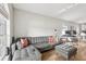 Open-concept living room with a gray sectional sofa, ottoman, and workstation at 2700 Palm Isle Way, Orlando, FL 32829