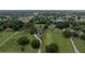 Expansive aerial view showing a lovely home, lush landscaping, surrounding properties, and a tranquil neighborhood lake at 2851 Granada Blvd, Kissimmee, FL 34746
