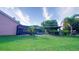 Lush backyard showcasing a screened-in pool, outdoor bar, and ample green space for outdoor activities at 2851 Granada Blvd, Kissimmee, FL 34746