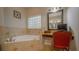 Relaxing bathroom with a soaking tub and vanity area with window at 2851 Granada Blvd, Kissimmee, FL 34746