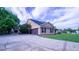 Side exterior showcasing the driveway and garage, complemented by lush landscaping and a well-kept lawn at 2851 Granada Blvd, Kissimmee, FL 34746