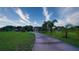 Expansive front yard featuring mature trees and long driveway leading to the home at 2851 Granada Blvd, Kissimmee, FL 34746