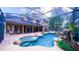 A beautiful screened-in pool with a rock waterfall and lush landscaping at 2851 Granada Blvd, Kissimmee, FL 34746