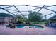Screened in patio boasts a luxurious pool with a waterfall and lush greenery in the background at 2851 Granada Blvd, Kissimmee, FL 34746
