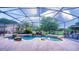 A backyard oasis featuring a custom pool, spa, rock waterfall, and screened enclosure at 2851 Granada Blvd, Kissimmee, FL 34746