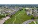 Aerial view showcasing a neighborhood bordering a lush golf course with mature trees at 3161 Timberly Ln, Lakeland, FL 33810