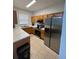 Well-lit kitchen equipped with stainless steel appliances, ample wood cabinetry and stone countertops at 324 Palermo St, Davenport, FL 33897