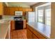 Well-lit kitchen featuring wood cabinets, island, white appliances, and tile flooring at 3267 Villa Way Cir, St Cloud, FL 34769