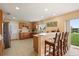 Spacious kitchen with light wood cabinets, a breakfast bar, and a view of the backyard at 3335 Whistling Trl, St Cloud, FL 34772