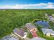 Aerial view showcases a home, a pond and views of lush green trees from above at 341 Whittier St, Davenport, FL 33896