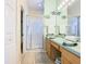 Bathroom with walk-in shower, neutral tile, and light wood cabinets at 341 Whittier St, Davenport, FL 33896