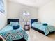 Bright bedroom with two twin beds and a decorative window at 341 Whittier St, Davenport, FL 33896