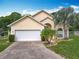 Charming one story home featuring a two-car garage, manicured landscaping, and a large driveway at 341 Whittier St, Davenport, FL 33896