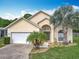 Charming one story home featuring a two-car garage, manicured landscaping, and a large driveway at 341 Whittier St, Davenport, FL 33896