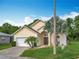 Charming one-story home featuring a two-car garage, stucco facade, and tropical landscaping at 341 Whittier St, Davenport, FL 33896