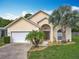 Charming one story home featuring a two-car garage, manicured landscaping, and a large driveway at 341 Whittier St, Davenport, FL 33896