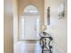 Bright foyer with tile flooring, decorative art piece, glass table with lamp, and a white front door at 341 Whittier St, Davenport, FL 33896