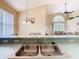 Kitchen sink view with faucet, backsplash, and a view of the dining and living areas at 341 Whittier St, Davenport, FL 33896
