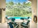 Screened in pool and lanai area with ample seating and dining with views of natural lush trees at 341 Whittier St, Davenport, FL 33896