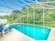 Refreshing pool with clear blue water surrounded by a screened in patio at 341 Whittier St, Davenport, FL 33896