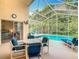 Relaxing screened-in pool area features a patio table, chairs, and lounge chairs at 341 Whittier St, Davenport, FL 33896