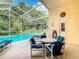 Enclosed pool area with lounge chairs, outdoor seating and a view of wooded backyard at 341 Whittier St, Davenport, FL 33896