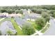 An aerial view reveals houses with screened pools, solar panels, and lush trees in a residential neighborhood at 350 Scrub Jay Way, Davenport, FL 33896