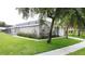 Charming single-story home featuring a well-manicured lawn, mature trees, and neutral stucco exterior at 350 Scrub Jay Way, Davenport, FL 33896