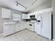 Well-lit kitchen with white cabinets, tiled floor, and stainless steel appliances for modern living at 350 Scrub Jay Way, Davenport, FL 33896