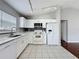 Modern kitchen with sleek white appliances, tile floors, and ample counter space, open to living area at 350 Scrub Jay Way, Davenport, FL 33896